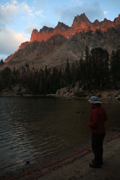 Serrate Ridge above Quiet Lake lit by the sun passing between cloud layers as it sets.
