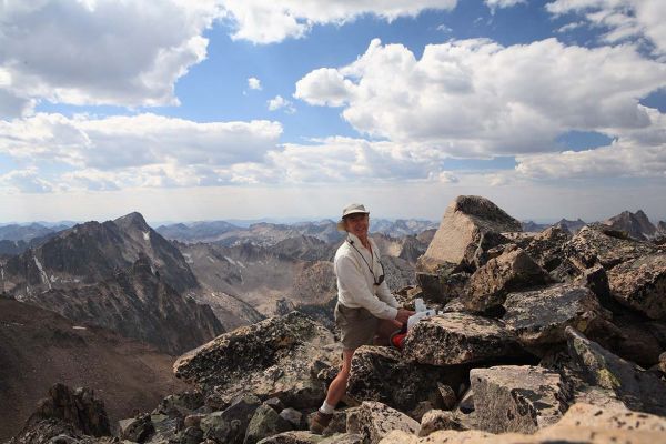 Signing the summit register; the view west.
