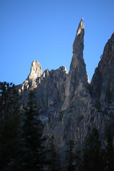 Just north of the pinnacle, catching early morning sunlight, is a formation that looks like a shark fin.
