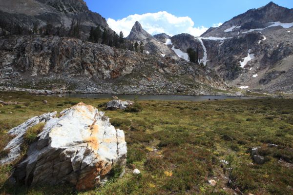 An inviting meadow in the hanging valley above the first two tarns.  The left snow couloir leads into the basin below Thompson Peak.
