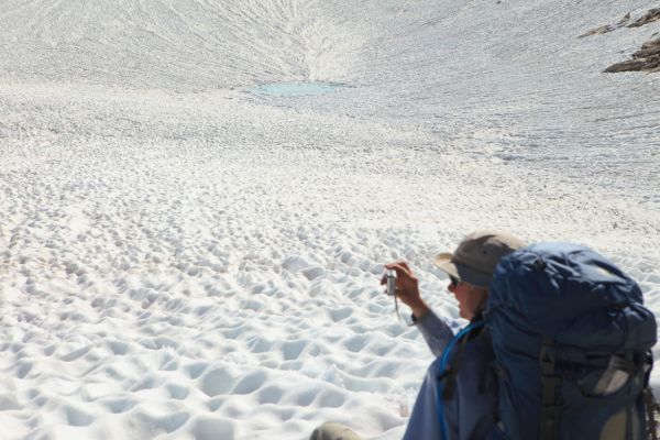 The Professor photographs a suncupped snowfield in the hanging valley at 11250' southeast of Sky Pilot Col.
