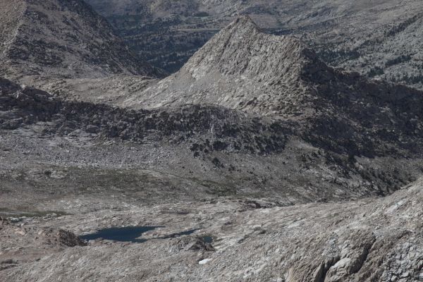 Northwest from the summit of Mt. Solomons, the JMT descends to the right (north) into lower Evolution Basin in front of Peak 12245' before reaching Sapphire Lake.  Evolution Valley is seen beyond the the gap between Peak 12242' and Peak 12245', above the lake in the left foreground.
