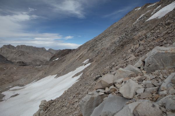 The the north face of Mt. Solomons, from just above the saddle below the west ridge.  The northeast shoulder follows the skyline from Muir Pass, above the snowfield on the left (north).
