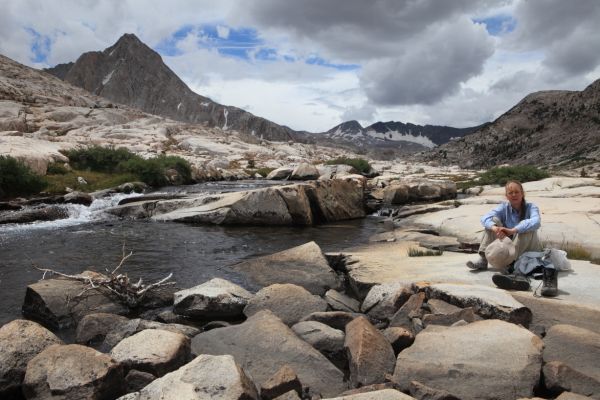 The professor relaxes along Evolution Creek below Sapphire Lake.  Mt. Spencer rises above the basin on the left (east).  Snow covered Goddard Divide under threatening clouds.
