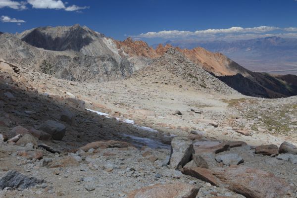 The route descends on a sketchy trail on the left (west) side of the drainage near the grassy area, below Peak 12373 (in the center of the photo).
