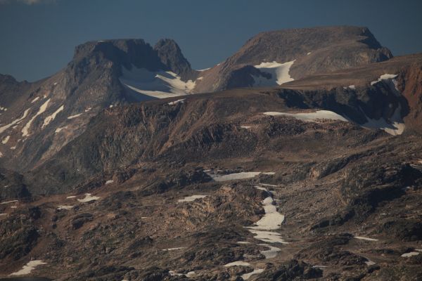 Sky Pilot Mountain is the more rounded summit on a separate ridge behind the flat topped peak immediately to its left.  The flat topped peak above and left of the large snowfield forms part of a ridge in front of Sky Pilot Mountain.
