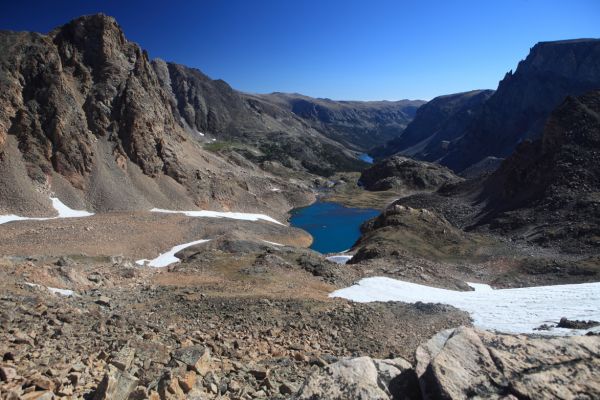 East from the top of the divide, Sky Pilot Mountain (left) rises above Sky Pilot Lake (10480').  The dark, flat-topped peak on the right is Beartooth Mountain.
