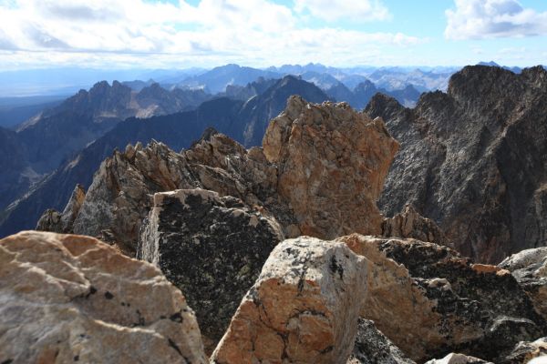 The orange block in the foreground is the east summit of Thompson peak, reached by heading to the right (east) at the notch at the top of the couloir above the Thompson/Mickeys Spire Saddle.
