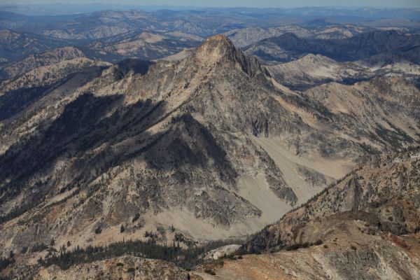 Mt. Regan, west northwest from the summit of Thompson Peak.  Sawtooth Lake is unseen on the right frame, in the valley in front of and below Regan.  The trees in the bottom left of photo mark the location of the trail descending west along the North Fork of Baron Creek.
