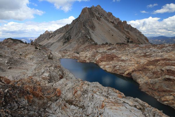 The deep lake is just west of the Thompson/Williams Saddle, and is the eastern-most of the three drainages in the upper lake basin south southeast of the Thompson/Mickeys Spire Saddle.  Past its outlet, the terrain drops steeply to the lake basin south of Goat Lake.
