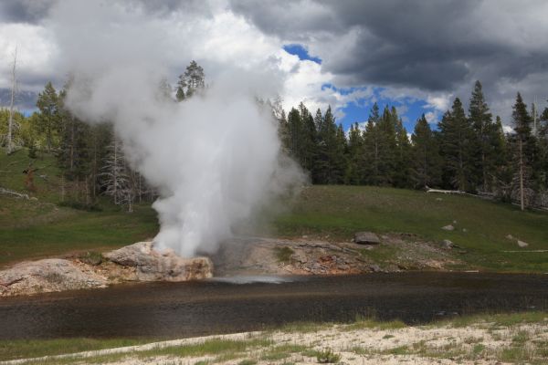 Dark ominous skies added to the drama at Riverside Geyser; Upper Geyser Basin.
