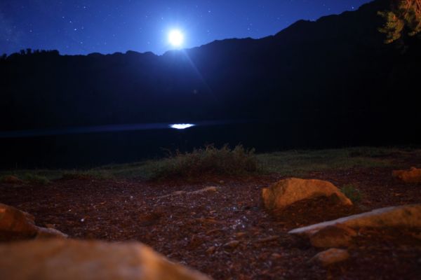 A thirty second exposure at the middle Chamberlain Lake (9477') as the full moon drops below the western horizon.  A headlamp, and some firelight paints the foreground.
