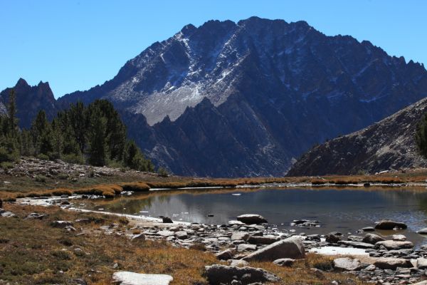 The north face of Castle Peak and the Serrate Ridge (center) rise above the tarn.
