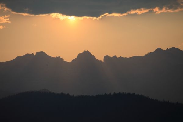 While driving out Fourth of July Creek Road, I am rewarded with a late afternoon view of the sun sinking below the clouds over the Sawtooth.
