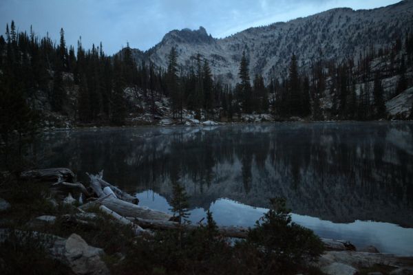 Shortly before 7 am, ground fog wisps across Wilson Lake, while low clouds hang on the peak to the west.
