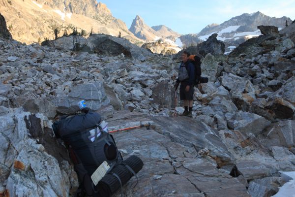 A short stretch of boulder hopping at the top of the snow couloir leads to a lake we cross on the left side.  Mike is ready to camp here.
