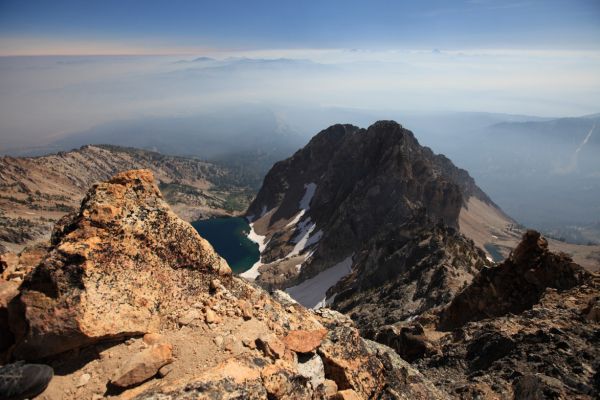 The "unnamed lake"; to the north, lying under the blanket of smoke is Stanley.  Snow still extends into the lake in the chutes on the rock faces above.  Compare this to summit photos in the gallery, "Thompson Peak, via Goat Lake, September 13, 2013" to see how much more snow fell last winter.
