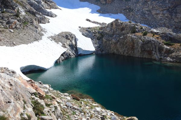 As I recall, there is a waterfall at the inlet of this lake.  There was so much snow this year, the waterfall is completely hidden under the snow couloir in the center of the photo!  See photos in the gallery, "Thompson Peak, via Goat Lake, September 13, 2013" to see the waterfall in a lower snow year.
