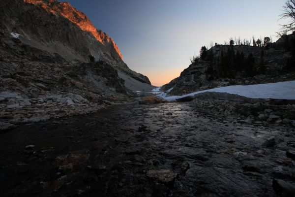 Coursing north toward the top of the couloir in the morning light, the stream draining the basin above Goat Lake.
