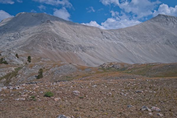 The plan is to ascend the ridge in the foreground to where it meets the rock (left of frame horizontally, middle of frame vertically), then climb up and right to the black rock outcrop (at the edge of the shadow.  There is supposed to be a sheep trail that leads up to the saddle from the top of the outcrop (trail follows the line of the shadow to a point left of and higher than the low point of the saddle).  The weather still looks good!
