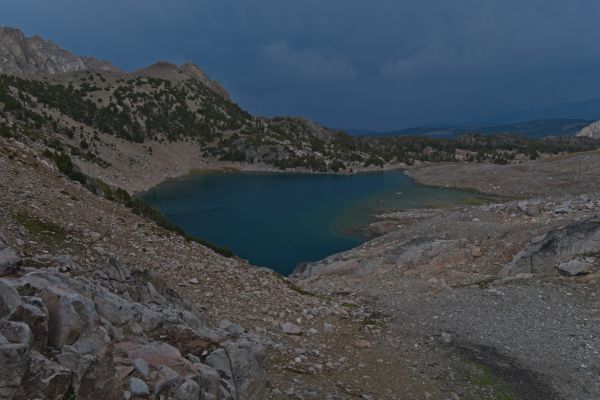 The thunderstorm moves east after unleashing thunder, lightning, and hail at the worst possible point of the crossing; the tedious traverse in loose scree leading to the exposed ridge.  Though carrying raingear, I did not dare stop for a moment.  Reaching the saddle, I knew the fastest descent route, having climbed here two years ago from the east side.  Nestled into the rocks, below the saddle, I put on dry clothes and warmed up.  This was one of the more frightening experiences I have had with lightning!
