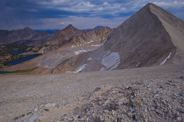 I arrive at the D. O. Lee/WCP-9 saddle about 5 pm, an hour and a half after starting.  I can see rain falling to the east-southeast, and felt a few drops on the ascent, but there was none of the feared lightning.  Below is the inlet to Cirque Lake.  Below that is Sapphire and Cove Lakes, all in the Big Boulder Lakes Basin.
