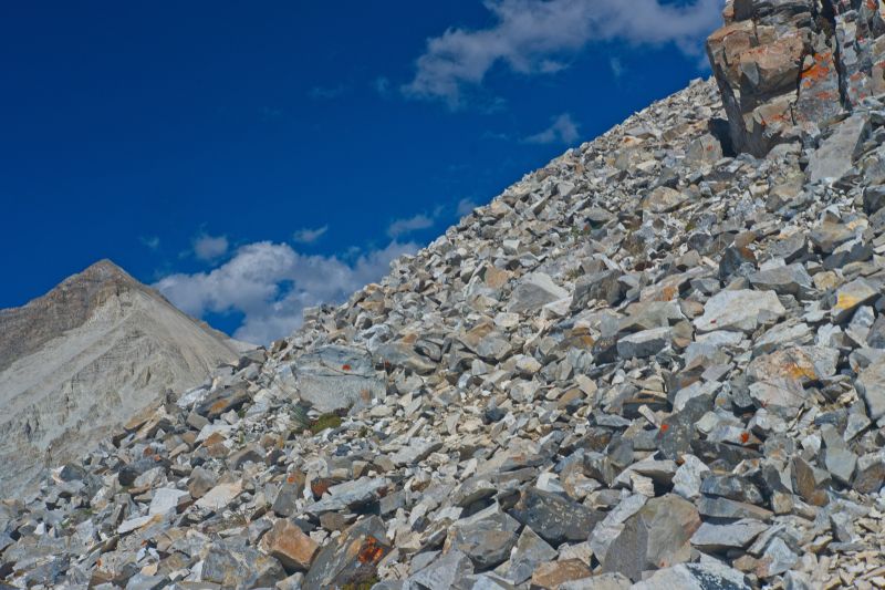 Arriving at the base of the outcrop, and welcome solid rock.  Three years ago at this same point in the climb, a thunderstorm rolled in from the west.  Lightening was flashing all about, accompanied by crashes of thunder.  I was pelted with hail.  I did not dare stop to put on my mountain parka.  One of the most frightening experiences I can recall in the mountains!
