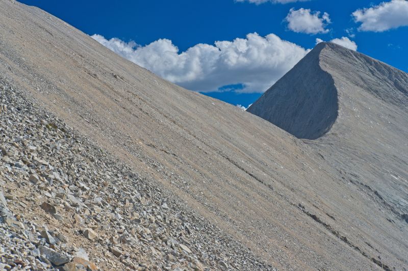 From the top of the outcrop, a game trail leads up an across to a point above the saddle, making it much easier to get across the upper section of loose scree.  D. O. Lee Peak rises from the south side of the saddle.
