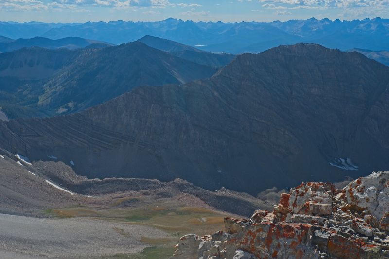 The view west south west from the rock outcrop just below the WCP-9 / D. O. Lee Peak saddle.  WCP-8 (10557') is on the right (north) of the foreground ridge which forms the southwest wall above the upper reaches of Bighorn Basin.  The Sawtooth crest is on the western horizon.  That might be Redfish Lake below the crest in the center of frame.
