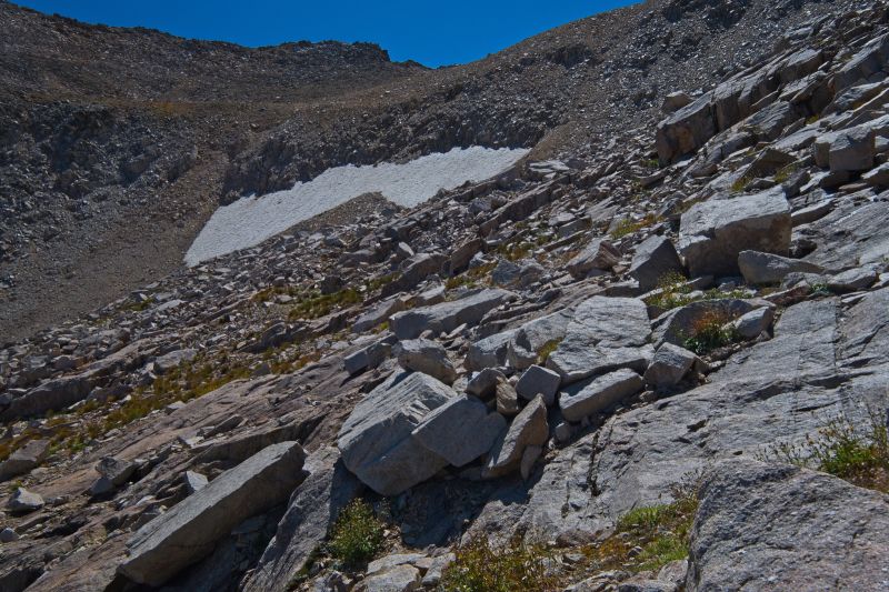 I gained the saddle right (west) of the low point, above the right edge if the perennial snowfield.  The rock is most unstable just before reaching the saddle.  I look for the most solid rock traversing up to the saddle.
