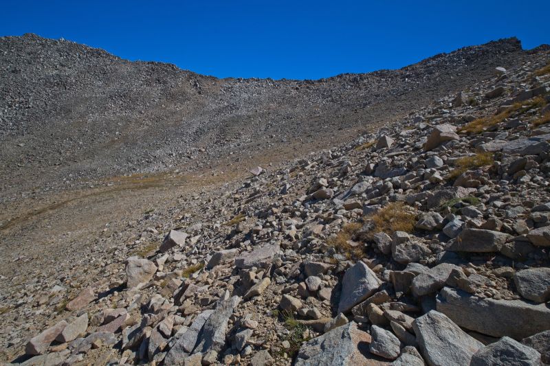 South southeast from the 'lower saddle' (just left of center of frame) to the pass leading to Boulder Chain Lakes Basin, on the skyline mid-frame.  If one climbs due south from the 'lower saddle', there is a pass (lower than the correct pass) on frame right that drops into a drainage east of Warm Springs Creek
