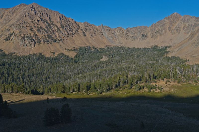 The steep climb to the ridge above Ants Basin is in the shade by the time I reach it.  In the center of the skyline is the pinnacle just south of Devil's Staircase.  The trail to Born Lakes is on the right (south) of the photo.
