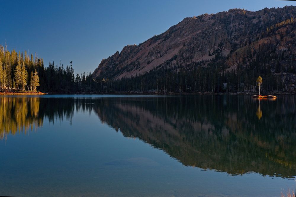 The view north across Imogene Lake to the outlet; morning.
