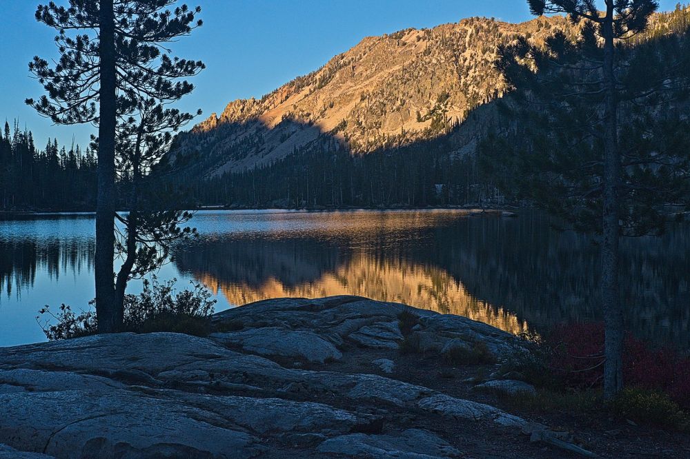 View north across Lake Imogene, already in shadow, reflects light from the steep eastern slopes rising above the lake.
