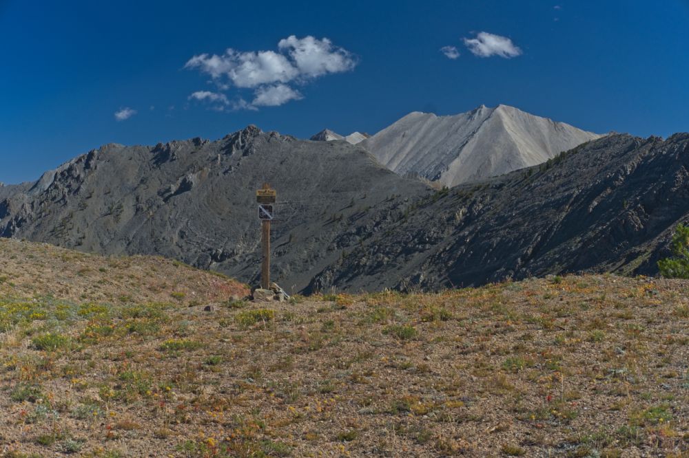 The first view of the White Clouds;  WCP-8 (10557'), below the cloud on the right.  The ridge to the right leads to D. O. Lee Peak (11342') 0.9 mile east hidden from view.  Limestone gives The White Cloud Peaks their stark white appearance.  This same feature is visible from the west side of Toxaway Lake in the Sawtooth range across the valley to the W.
