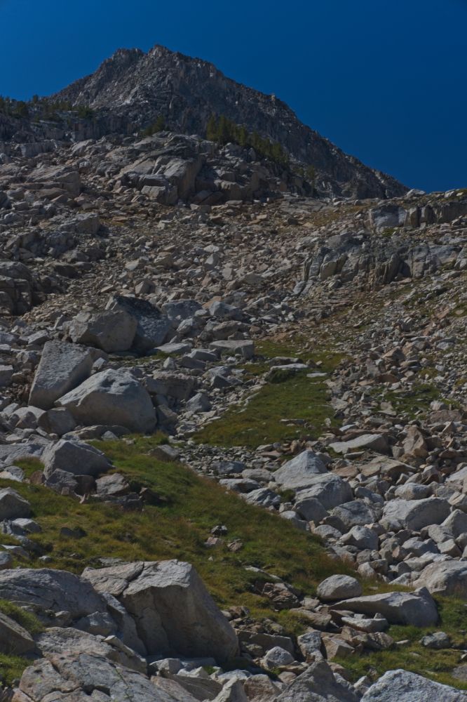 The route climbs up and left (SW). Into a protected drainage with a stream that was running.  Every time I have climbed this route, the stream has been running.  There is no need to carry water up to the tarns encountered higher.  The route is grassy, interspersed with granite friction slabs.
