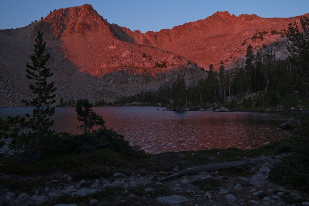 Alpenglow; peaks SW of Scoop Lake.  In the time I spent talking with Derek, a group of four arrived at Scoop Lake and set up camp at the spot I was heading to on the other side of the peninsula near the SW end of the lake.  I backtrack to a site near the outlet of Scoop Lake.  Last year, that site was occupied by another party.  The tent was a tight fit, and surprisingly, I was able to easily sink all but one of the 8 stakes.  I set the hang, made dinner, and got my rod prepared for morning.  No trout tonight, so I made the heavier of the remaining dinners to lighten the load for the hike out.  The 6 day old weather report remained accurate.  We were in for some weather!
