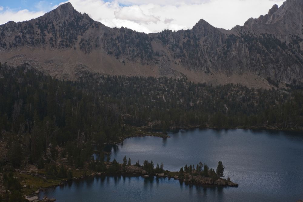 The clouds had already closed in, shading the steep climb (S) out of Scoop Lake toward Windy Devil.  A wet sleet began falling.  I thought about digging in the top packet of the pack for the rain cover I remembered to bring this trip, but figured it would stop by the time I found it.  I kept climbing.  The peninsula I enjoy fishing from is in the foreground.  The breeze continues to blow across the lake.
